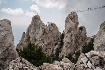 Suspension bridge over the canyon at the top of Ai-Petri Mountain in Crimea. Tourists travelers who...