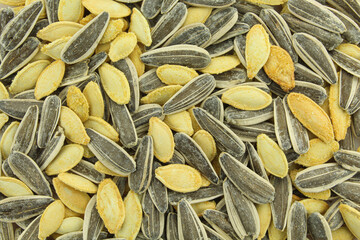 Background texture full of mixed salty pumpkin and sunflower seeds 