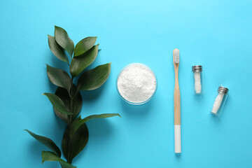 Bowl of tooth powder, brush, dental flosses and plant on turquoise background, flat lay. Space for...
