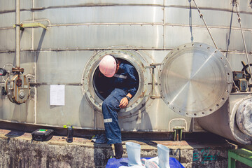 Male worker into  manhole fuel tank oil chemical protective clothing