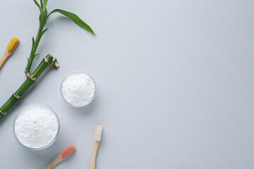 Tooth powder, brushes and bamboo stem on white background, flat lay. Space for text