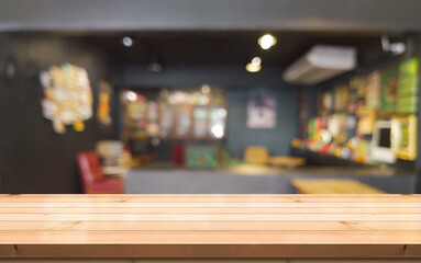 Empty wooden table top with lights bokeh on blur restaurant background.