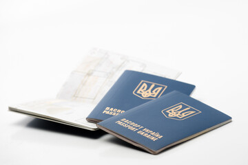 several passports of the citizen of Ukraine with a coat of arms on a wrapper lying on a white background