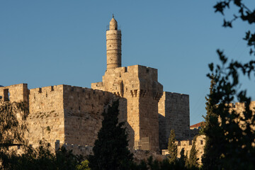 Afternoon view of the landmark, stone Tower of David minaret as golden sunlight strikes the ancient walls of the Old City of Jerusalem.