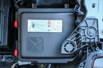 New vehicle battery cover with warning labels