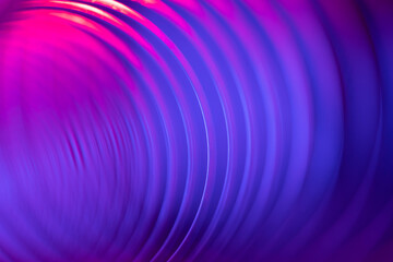 Closeup of coiled metal spring with sufficiently high strength and elastic properties in neon blue...