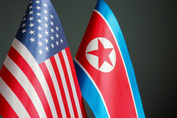 Flags of North Korea and the USA on a dark surface.