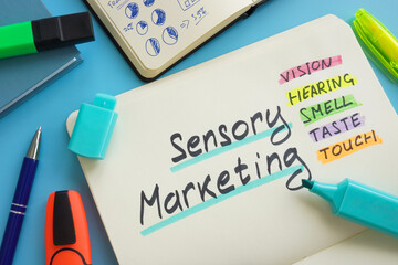 Open notepad and marks about Sensory marketing. - obrazy, fototapety, plakaty