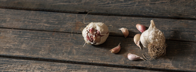 A scattering of garlic on a wooden texture. Concept: food, vegetables, agriculture