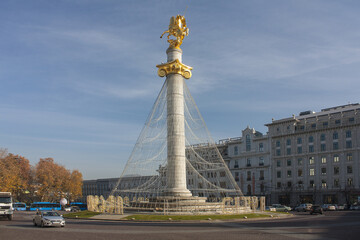 Fototapeta na wymiar Freedom Square with golden statue of St George on tall stone column in Tbilisi, Georgia