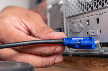 male hand installing VGA cable in a cpu case, closeup