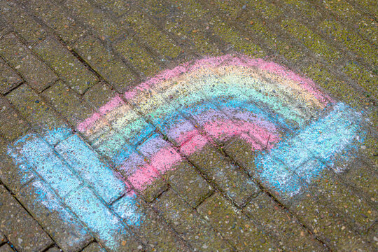Chalk drawing on the bricks floor with colourful rainbow, Multicolor hand sketch on playground, Chile activity recreation for children, Abstract background.