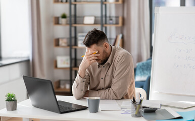 distance education, remote job and stress concept - tired male teacher with laptop computer working...