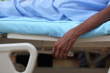 hand of patient sick  falling down from bed in hospital room. emergency case