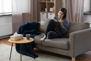 people, leisure and depression concept - sad woman with diary sitting on sofa at home