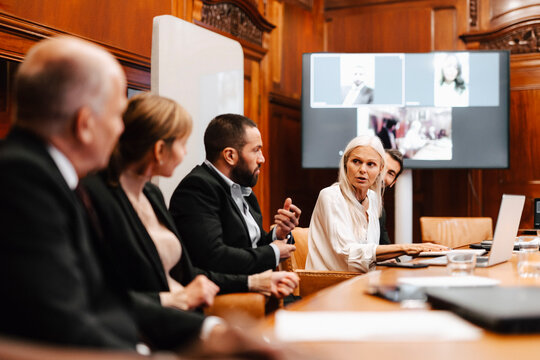 Female financial expert discussing with colleagues in meeting at board room