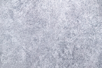 Light background of decorative plaster with abstract spots. Unusual texture of white or gray wall with beautiful patterns, creative surface background. Finishing coating for building cladding.