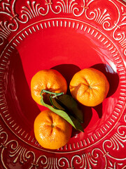 clementines in a red bowl