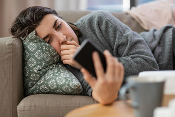 mental health, psychological help and depression concept - stressed woman with smartphone lying on...