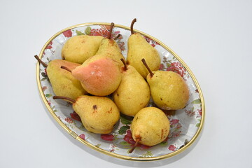 yellow pear on a plate on white background