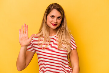 Young caucasian woman isolated on yellow background smiling cheerful showing number five with fingers.