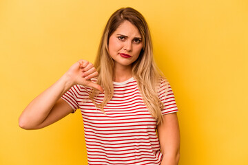 Young caucasian woman isolated on yellow background showing thumb down, disappointment concept.