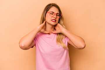 Young caucasian woman isolated on beige background suffering neck pain due to sedentary lifestyle.