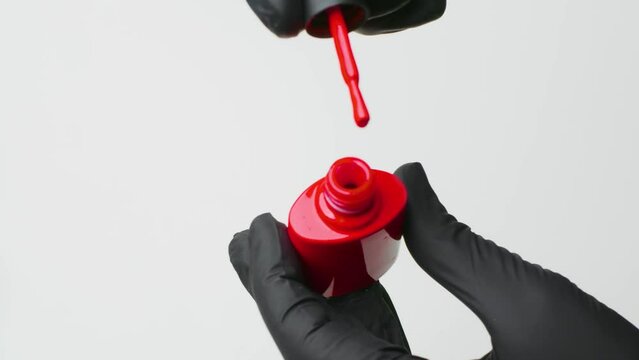 Manicurist opens a bottle of gel polish. close up