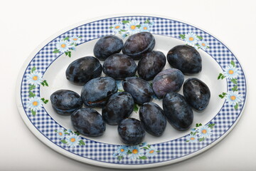 Fresh plums on plate .,