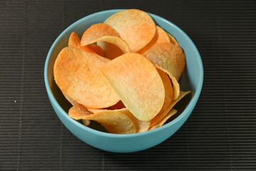 Spicy and flavorful chips, Mexican nacho chips  in a blue porcelain plate
