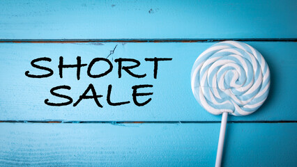 Short Sale. Blue candy on a stick and painted wooden background