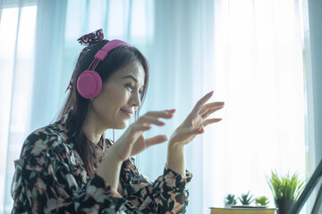 Fototapeta premium Asian woman having video call via computer in the home office.