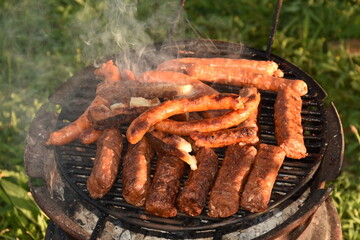 barbecue, spicy sausages and bacon in metal wheell