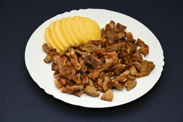mushrooms fried with goldene apples sliced on a white plate