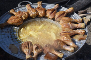 crispy chicken and fried potatoes on a cast iron disk