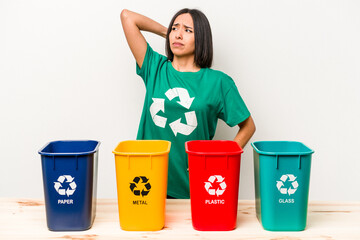 Young hispanic woman recycling isolated on white background touching back of head, thinking and making a choice.