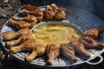 crispy chicken and fried potatoes on a cast iron disk