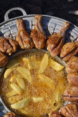 crispy chicken and fried potatoes on a cast iron disk