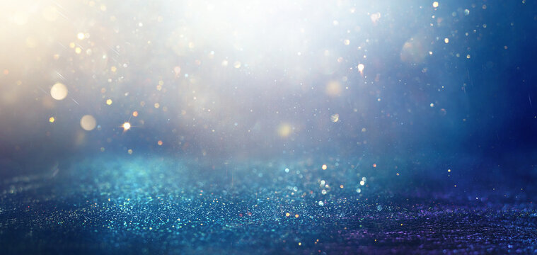 background of abstract glitter lights. gold and blue. de focused