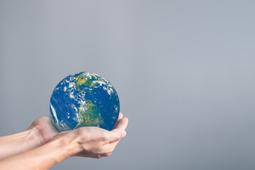 Hands holding earth globe on gray background, International human solidarity day concept, world...