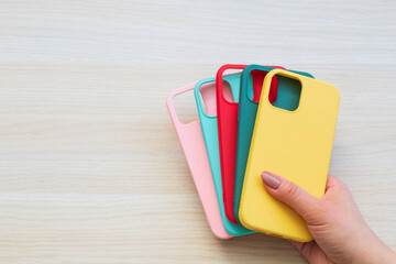 hands holding colorful smartphone cases