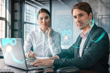 Businessman and businesswoman in formal wear working together to optimize IPO strategy at corporate fund. Financial chart hologram over office background with panoramic windows