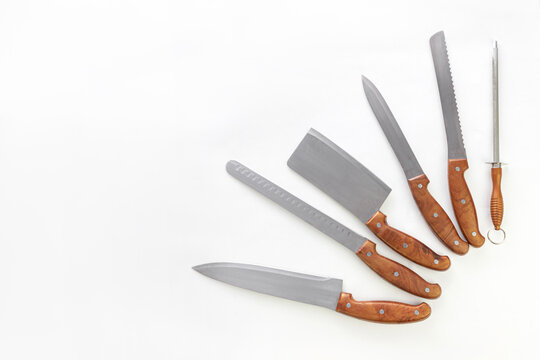 Set of professional kitchen knives on white background with copy space. Chef, restaurant or kitchen concept.