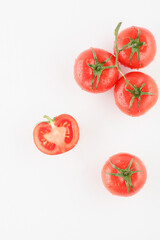 bunch of fresh red tomatoes with water drops on a white background