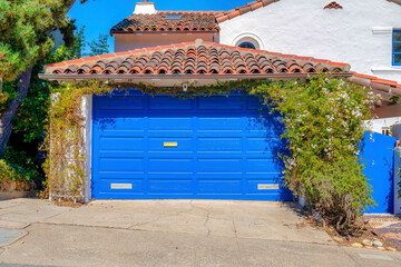 Garage of a mediterranean house with blue sectional garage door and gate in San Francisco, CA
