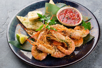 Fototapeta na wymiar Grilled tiger shrimp with parsley, red sauce, toast and lime on plate