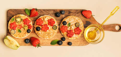 Sweet sandwiches peanut butter with fruits, berries with honey on a wooden board, top view. Banner Healthy tasty breakfast.