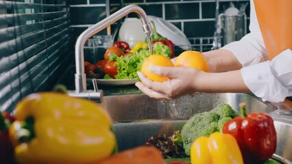 Hand of maid washing tomato fresh vegetables preparation healthy food in kitchen