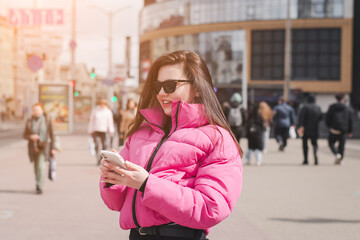 Stylish young girl with a phone on the city