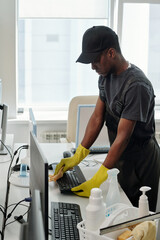 African American male staff of cleaning company in black t-shirt, cap and coveralls and yellow...
